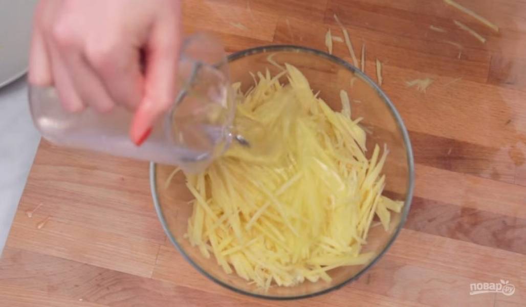 1. Картофель очистите от кожуры и с помощью терки натрите на тонкие полосочки. Затем залейте их холодной водой и оставьте на 10 минут, чтобы картофель отдал немного крахмала. 