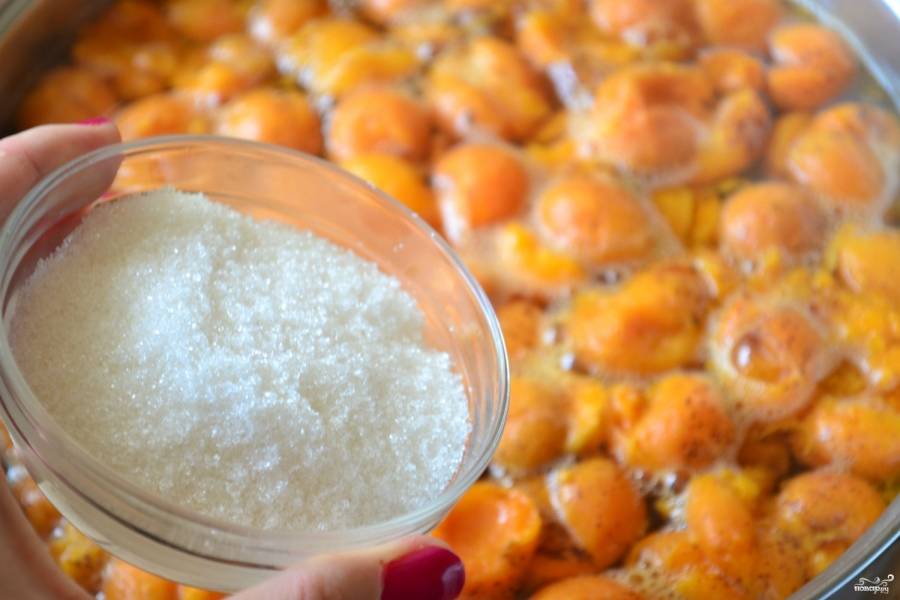 Когда вода с абрикосами снова закипит, всыпьте сахар. Обратите внимание, что вы можете регулировать сладость напитка по своему вкусу. На указанное количество воды мне хватает стакана сахара, но можно добавить и больше. 