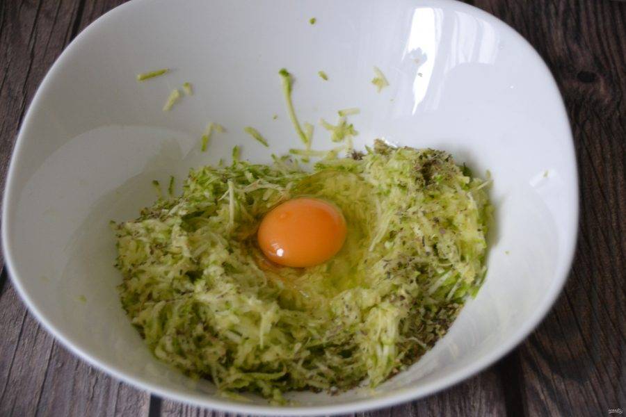 Добавьте к кабачку соль, ароматные травы по вашему вкусу, вбейте яйцо.