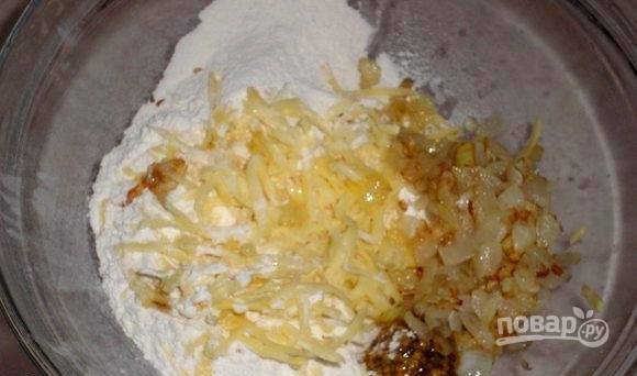 Мелко нашинкованный лук обжарьте до готовности в растительном масле. Потом соедините его с мукой, натёртым сыром, горчицей, мягким маслом, солью, разрыхлителем и солью.
