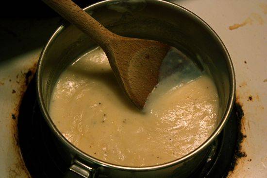 6. Последний этап, который входит в этот простой рецепт пирога с лисичками и сыром - это соус. Для его приготовления необходимо растопить в небольшом сотейнике сливочное масло, всыпать муку и обжарить ее около минутки. Влить тонкой струйкой молоко и всыпать тертый сыр. Добавить по вкусу соль, перец и проварить соус пару минут. Затем взбить яйца в небольшой мисочке и быстро влить в сотейник. Активно перемешать и сразу снять с огня. Выложить в соус грибы. 