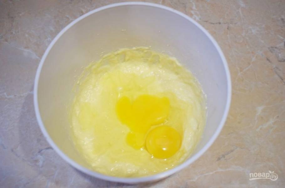 В чашу для приготовления теста соедините мягкое сливочное масло с сахарной пудрой. Взбейте до получения пышной массы. 
Затем добавьте в тесто яйца. Перемешайте.