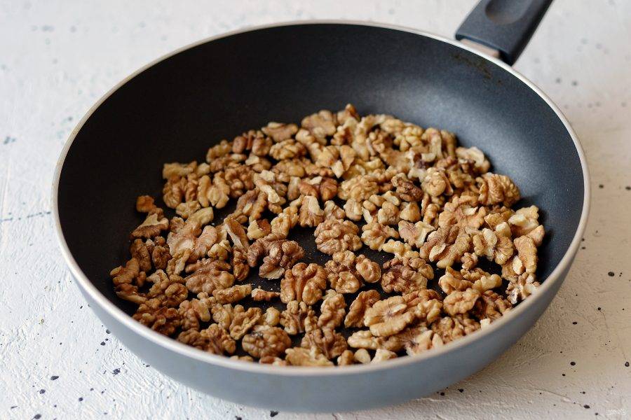 Обжарьте грецкие орехи на среднем огне до румяного цвета. Переложите в миску. 