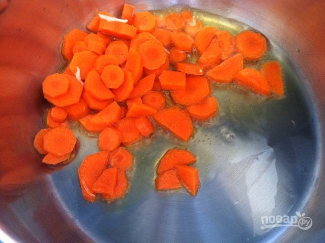 2. Разогрейте в кастрюле масло. Добавьте в него морковь. Обжарьте её 2 минуты. Затем добавьте сельдерей. Готовьте 1 минуту.