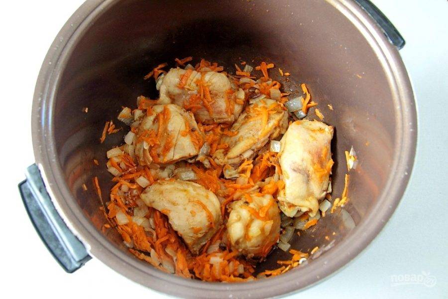 Обжарьте мясо с солью и специями до появления легкой румяной корочки, после чего добавьте тертую морковь и лук, нарезанный кубиками, и обжарьте все вместе еще около 10 минут.