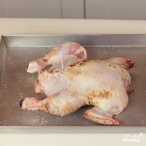 Ниткой свяжите крылья цыпленка - и в духовку. Выпекать 45 минут при 200 градусах, время от времени смазывая цыпленка растопленным маслом.