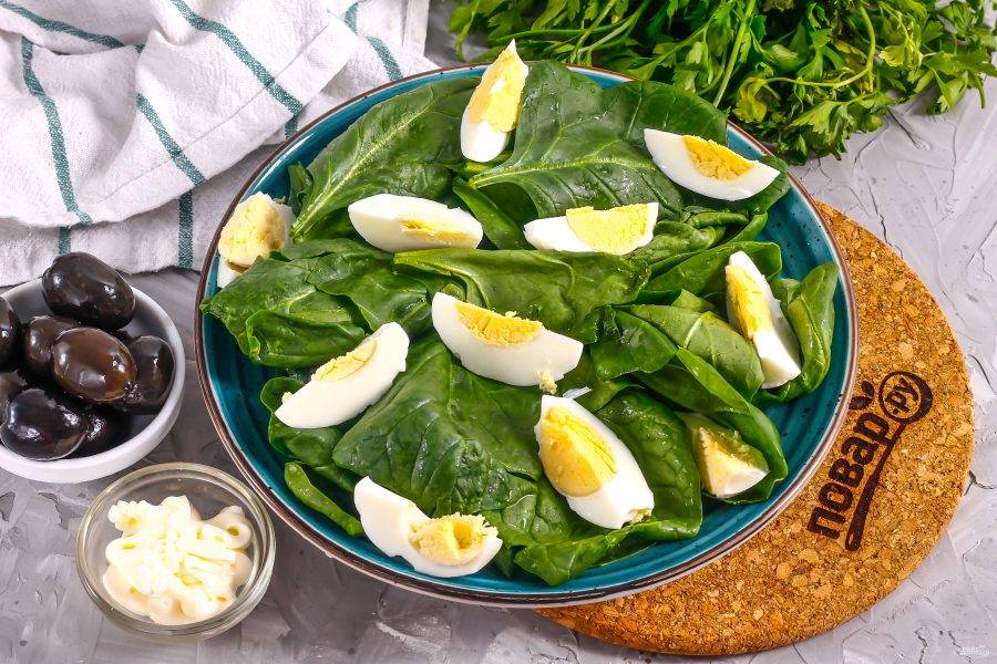 Очистите отварные куриные яйца от скорлупы, нарежьте четвертинками и выложите на тарелку.