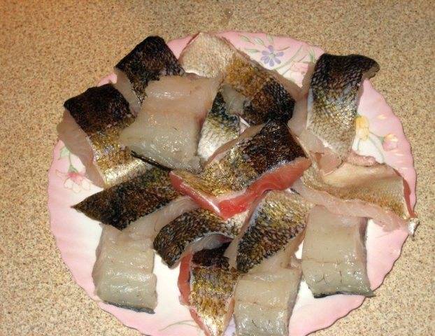 Остальную часть тушки рыбы разделываем на филе и нарезаем его на небольшие кусочки. Слегка посыпаем солью и перцем.