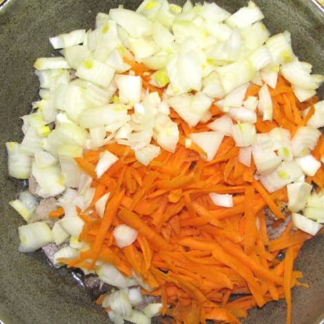 Морковь натираем на терке, лук режем кубиками и добавляем к мясу на сковородку. 
