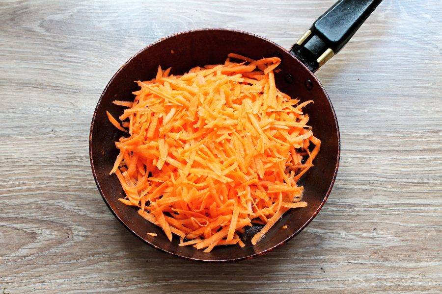 Морковь почистите и натрите на крупной терке. В сковороду налейте половину растительного масла и выложите морковь.