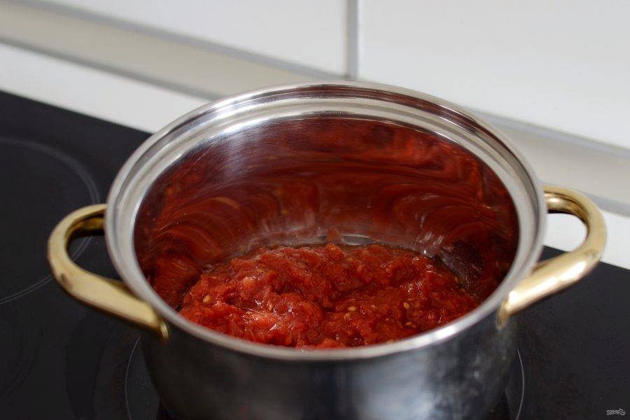 Помидоры натрите на крупной терке, переложите в кастрюлю, добавьте кетчуп и измельченный перец чили. Доведите смесь до кипения.