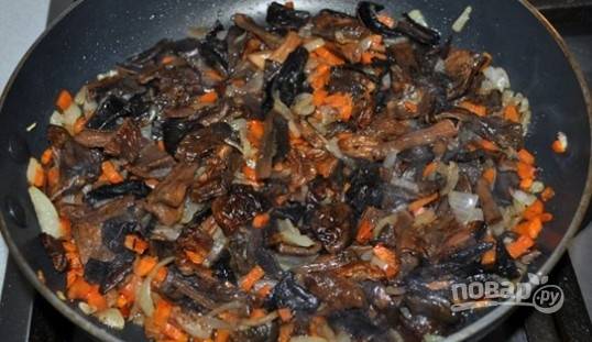 После этого добавьте в сковороду промытые грибы (кусочками). Тушите ингредиенты, помешивая, 10 минут.