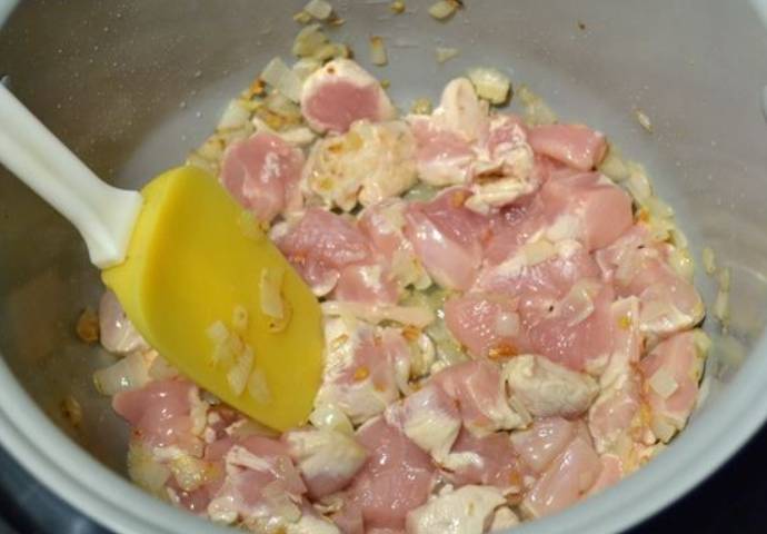 Теперь добавляем куриную грудку, порезанную порционными кусочками. Обжариваем до побеления мяса.