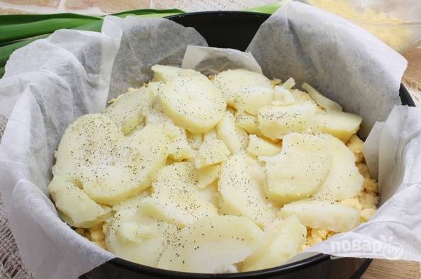 5. Выложите на тесто очищенный, нарезанный ломтиками картофель. Подсолите, поперчите по вкусу. 