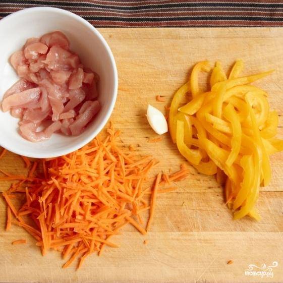 Занимаемся ингредиентами: морковь нарезаем соломкой (можно натереть на крупной терке), перец нарезаем тонкими ломтиками. Куриное филе нарезаем на небольшие кусочки - как на фото.