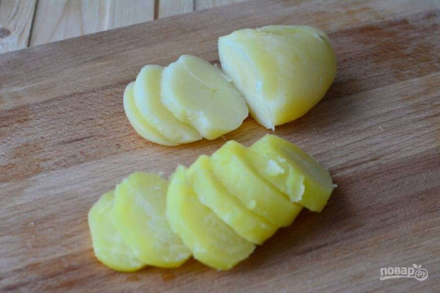 Промытый картофель отварите в мундире. Остудите его, почистите и нарежьте кружками.