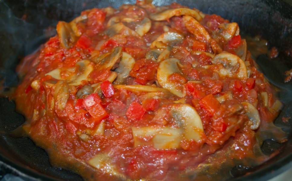 Теперь добавляем томаты (вместе с соком) и сахар. Тщательно перемешиваем, кладем соль и перец (если нужно). Тушим на медленном огне 15-20 минут до мягкости овощей и загустения соуса. 