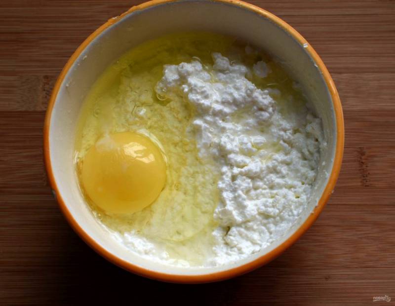 Творог смешайте со сметаной, солью и сахаром, хорошо разотрите вилкой. Добавьте яйцо.