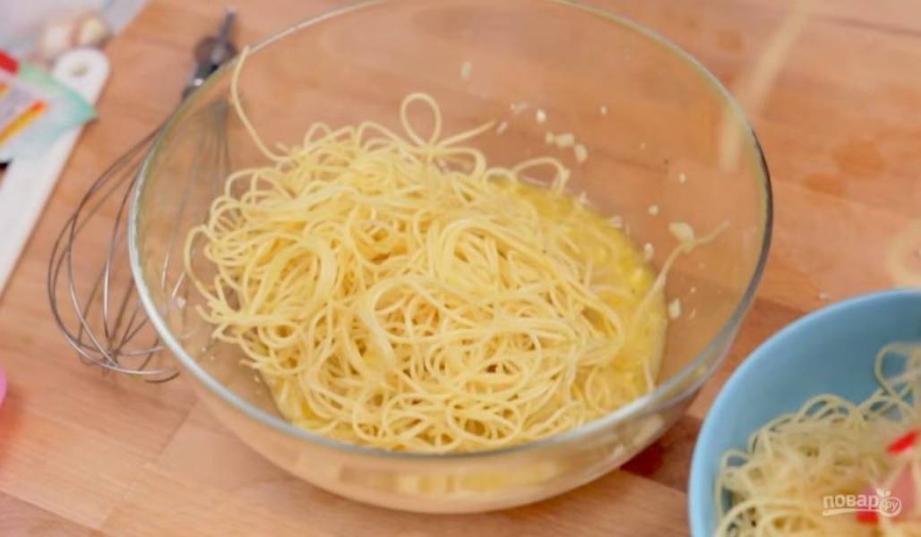 2. Далее готовые спагетти опустите в яичную смесь и хорошо перемешайте, чтобы все спагетти покрылись яичной смесью. 