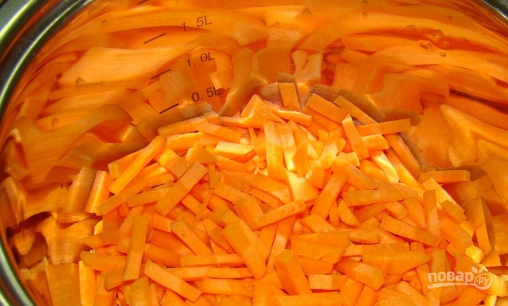 Морковь очистите и помойте. Нарежьте ее соломкой и выложите в глубокую кастрюлю. Вылейте в кастрюлю половину томатного соуса. 