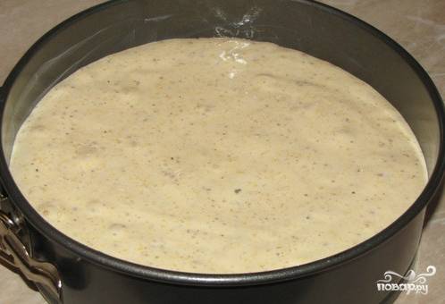 Добавим в тесто несколько ложек тертых орехов и еще раз перемешаем. Теперь берем форму для выпечки и смазываем сливочным маслом. Выкладываем тесто в форму, нежно разравнивая по поверхности.