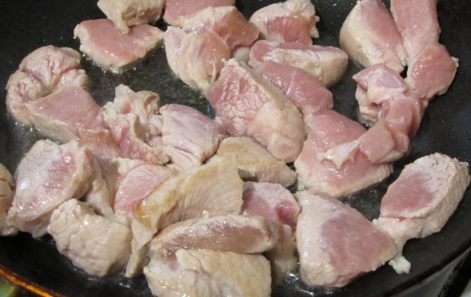 Разогрейте в сковороде растительное масло, обжарьте кусочки свинины (примерно 10 минут).