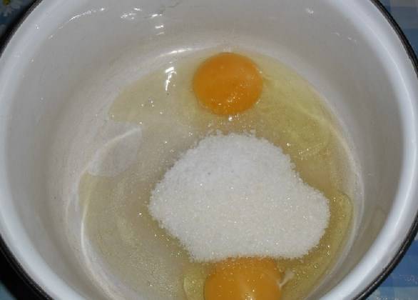 В кастрюлю положите яйца, соль и сахар. Слегка взбейте их венчиком.
