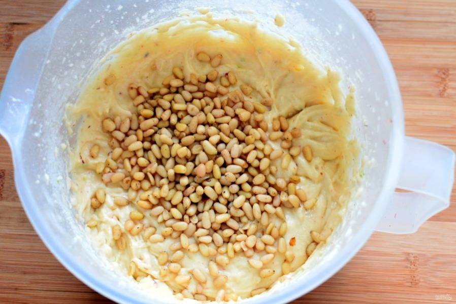 На низкой скорости миксера вымешайте легкое тесто. Лопаткой вмешайте в него кедровые орешки. Лучше предварительно прокалить их на сухой сковороде до усиления аромата.


