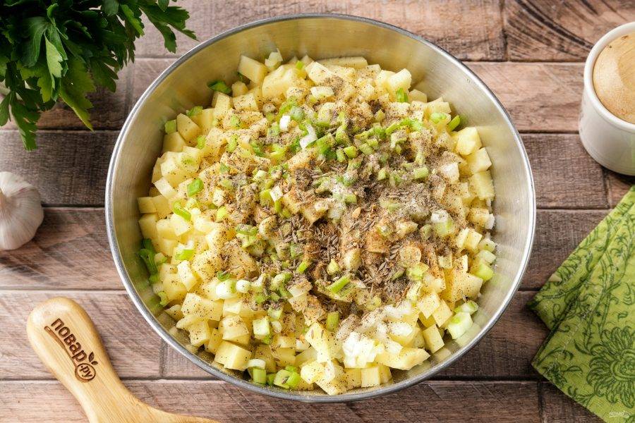Картофель нарежьте кубиками чуть поменьше, а лук желательно нарезать максимально мелко, насколько это возможно. Зелёный лук промойте, обсушите и так же порубите ножом. Добавьте к начинке 1 ст.л. растительного масла, соль, молотый чёрный перец и любимые специи по вкусу.