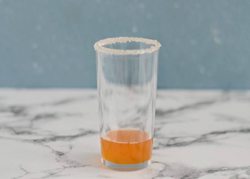 На дно стакана налейте сироп, добавьте пару кубиков льда и залейте газированной водой. 