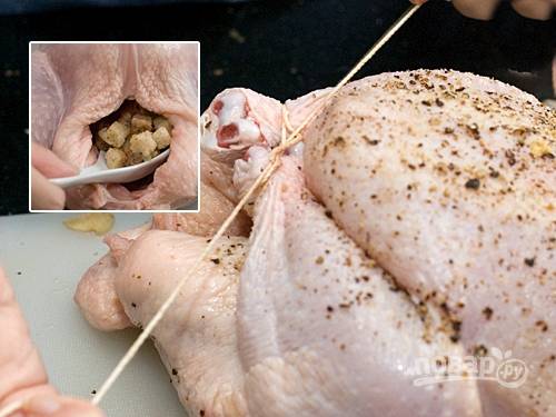 4. Свяжите ножки цыпленка плотной нитью и начините полость начинкой из овощей.
