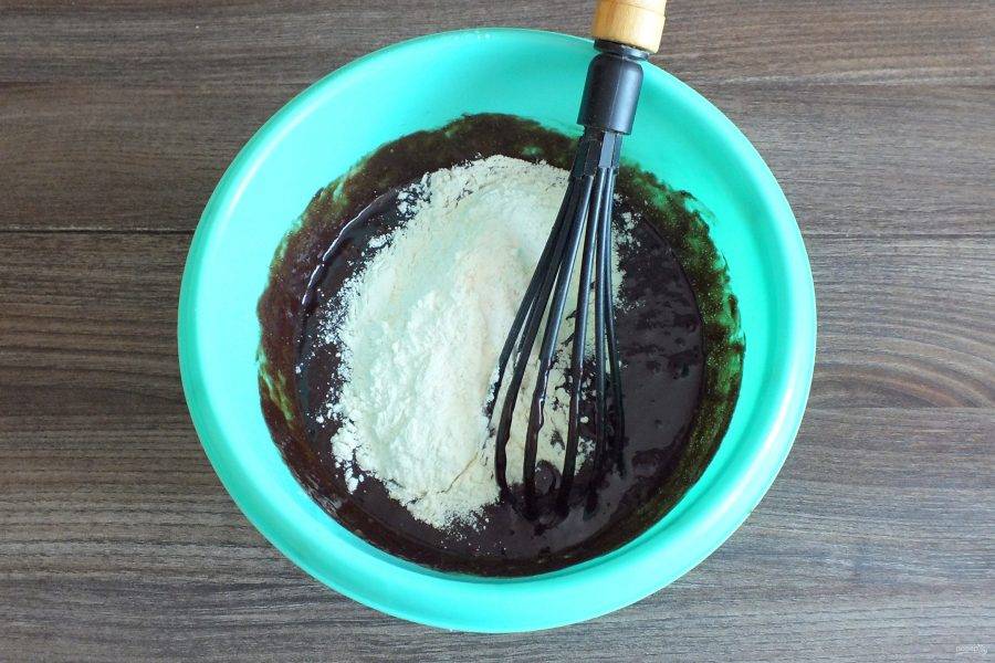 В шоколадную массу добавьте мучную смесь. Аккуратно перемешайте тесто.