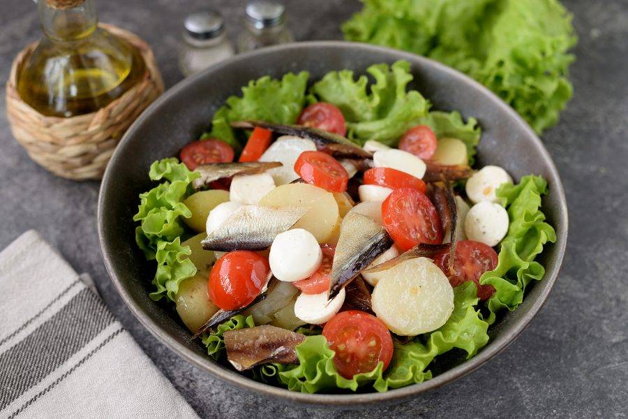 Выложите заправленные овощи с сыром и рыбой на салат.