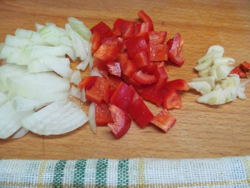 Нарежьте мелким кубиком лук, болгарский перец, чеснок и перец чили или острый красный перец. 