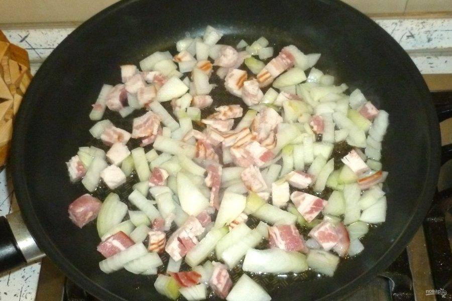 В большой сковороде разогрейте ложку масла и обжарьте бекон с луком.