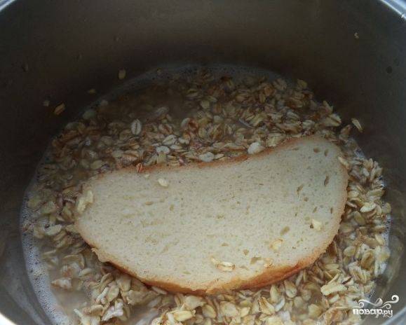 Возьмите ломтик белого хлеба и положите его к хлопьям, залитым теплой водой. Вы можете использовать свежий или черствый хлеб, а можете вовсе добавить сухарики. Накройте посуду крышкой, оберните полотенцем и поставьте в теплое местечко на пару дней.