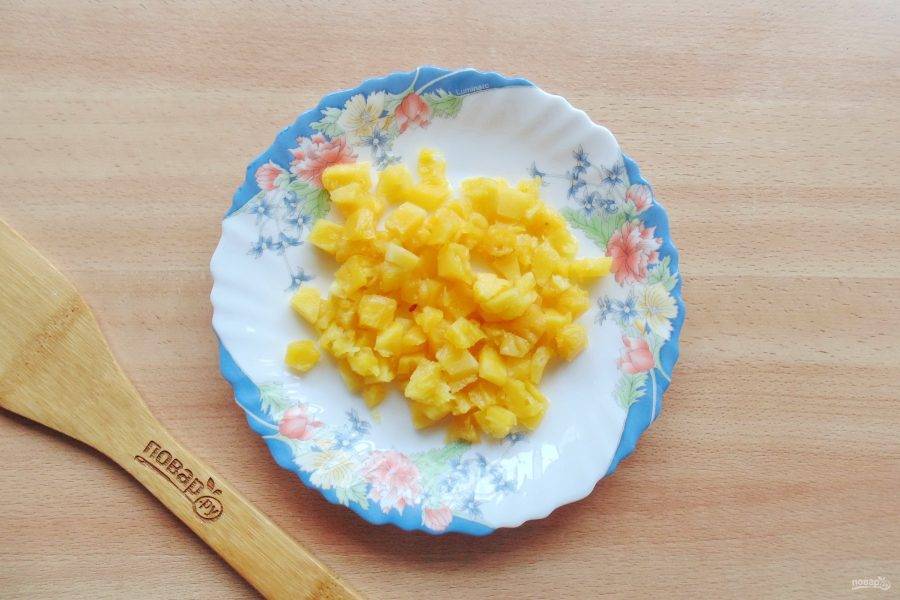Консервированный ананас нарежьте мелкими кубиками.