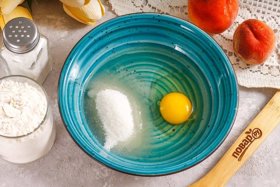 В глубокую емкость влейте растительное масло, вбейте куриное яйцо и всыпьте соль, сахар. Тщательно перемешайте.