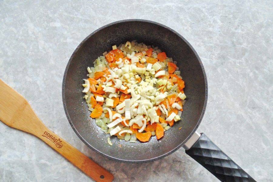 Стебель сельдерея вымойте, нарежьте небольшими кружками и добавьте к луку и моркови, перемешайте и потушите ещё 5-7 минут.