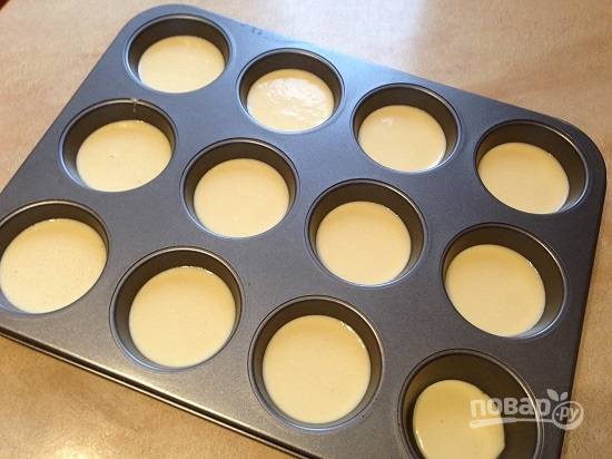 6. Разливаем тесто по формочкам для кексов, нам их понадобится 12 штук. Наполняем формочки чуть больше чем на половину объема.