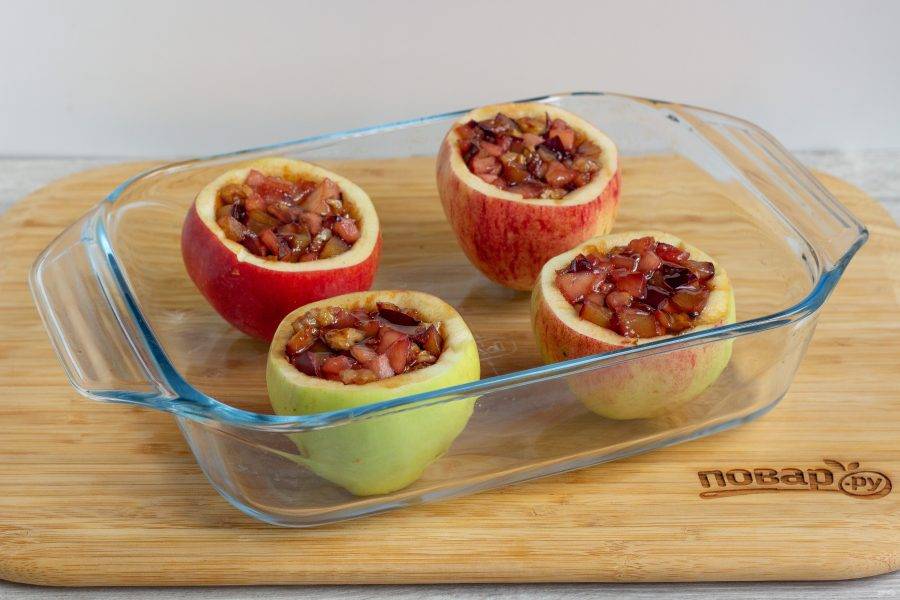 Поставьте яблоки в форму для запекания и наполните начинкой. Полейте каждое яблоко буквально 0,5 ч. л. меда, для аромата.