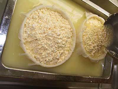 6. Аккуратно переложить сырную массу в формы, постепенно добавляя из кастрюли. Этот процесс может немало времени, так как сразу будет выделяться довольно много сыворотки. 