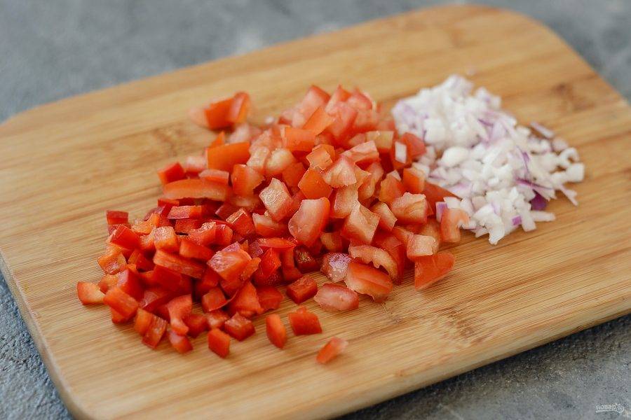 В это время подготовьте овощи. Нарежьте помидоры, болгарский перец и красный лук на мелкие кубики.
