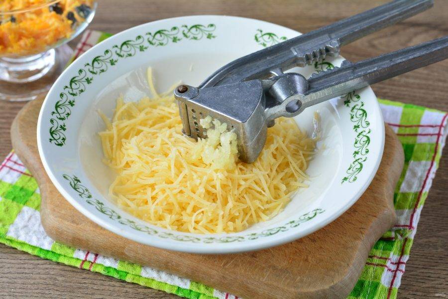 Натрите на терке сыр, выдавите чеснок через пресс и перемешайте. Чеснок добавляйте по вкусу — 1-2 зубчика.