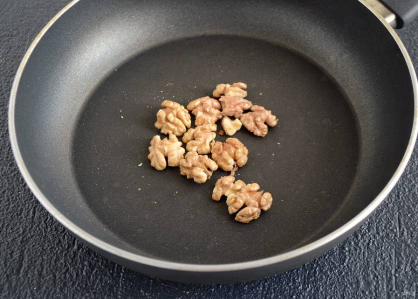 Грецкие орехи обжарьте на сухой сковороде до золотистого цвета, затем порубите ножом на маленькие кусочки. 
