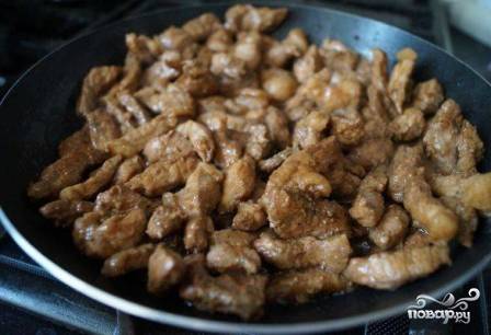 Нагреваем на среднем огне сковороду с растительным маслом и выкладываем мясо, слегка отжав его от маринада. Обжариваем до легкого подрумянивания. Затем добавляем оставшийся маринад и протушим свинину минут 5.