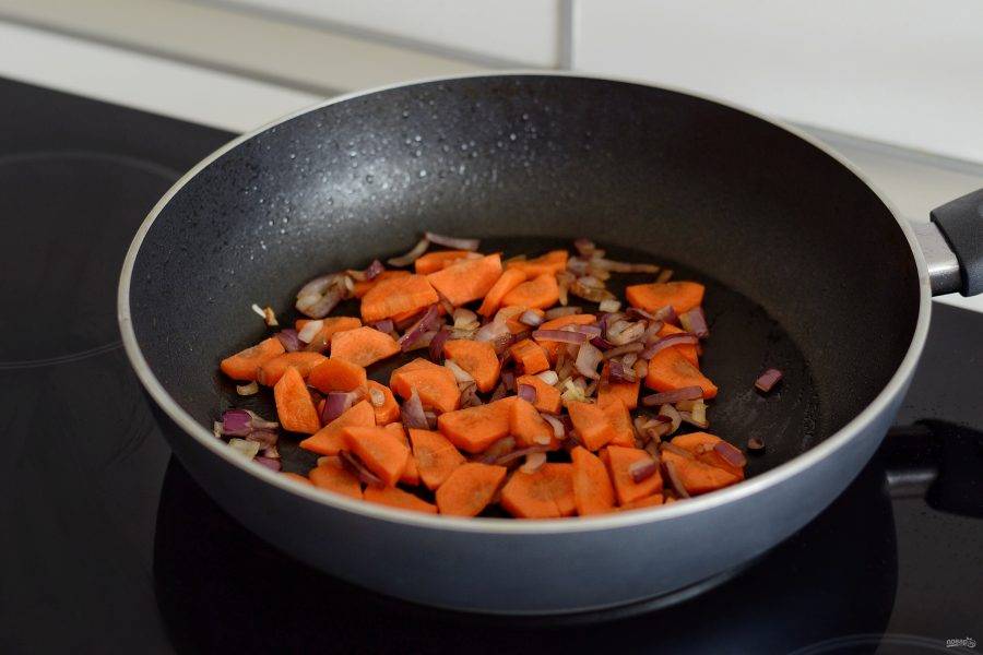 Лук нарежьте кубиками, обжаривайте 3 минуты, затем добавьте морковь и жарьте овощи ещё пару минут. 