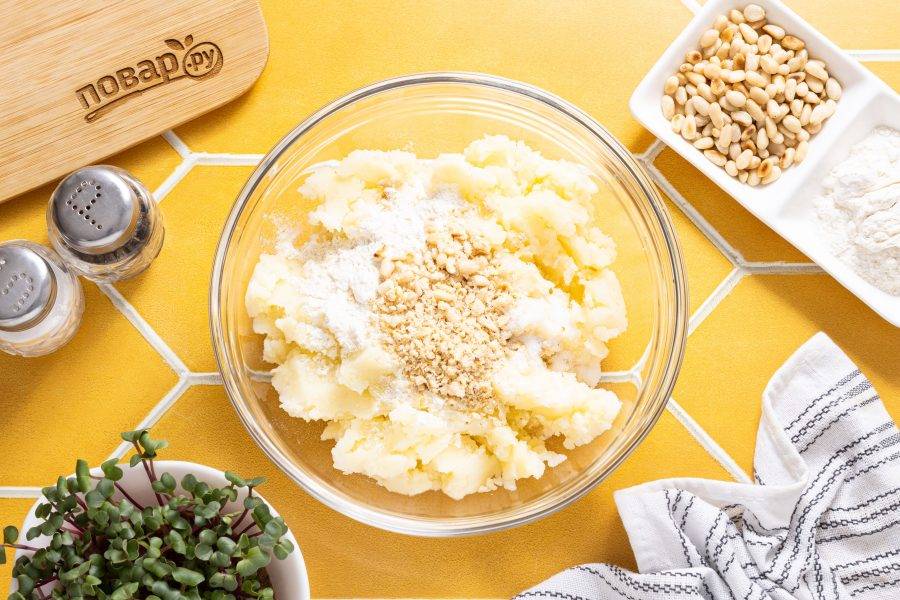Добавьте в полученное пюре еще чуть соли по вкусу, муку и крупно порубленные кедровые орешки.