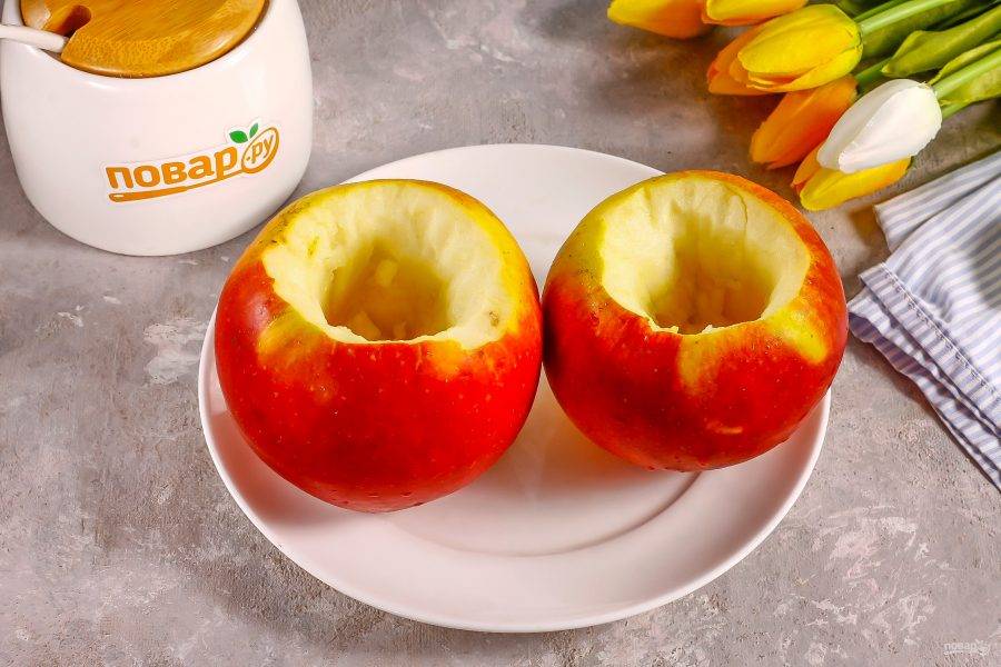 Яблоки промойте в воде и вырежьте из них семенные блоки, стараясь не повредить дно фруктов.