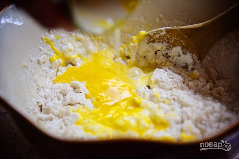 6. Влейте половину жидких ингредиентов в сухие. Добавьте слегка взбитые яйца и сливочное масло. 